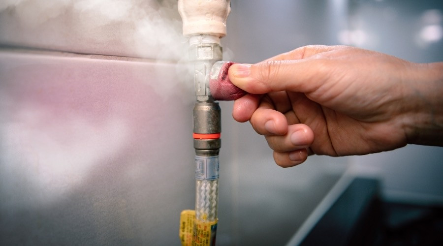 Hand turning a gas appliance shutoff valve
